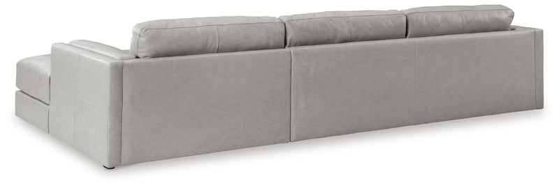 Ashley Furniture Amiata sectional with chaise, showing the back view of the beige fabric sofa and chaise lounge in a modern living room.