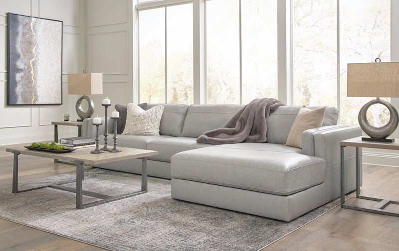 Ashley Furniture Amiata sectional with chaise, featuring plush cushions and neutral upholstery, shown with decorative pillows.