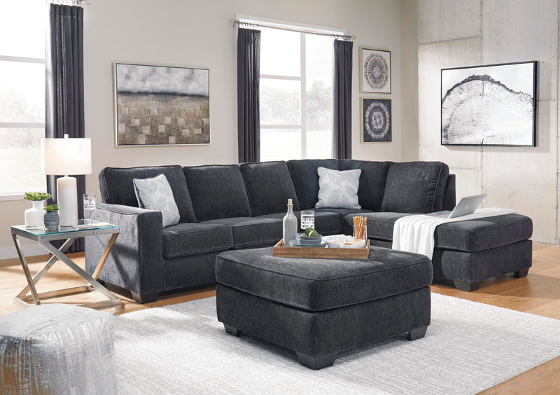 Ashley Furniture Altari sleeper sectional with chaise, showing plush fabric upholstery and spacious seating with a built-in bed feature.
