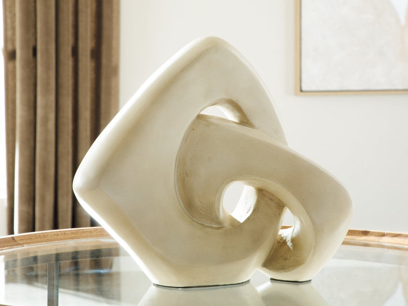 Ashley Furniture Feebs sculpture, modern abstract sculpture with smooth, flowing shapes in neutral tones, displayed on a plain background.