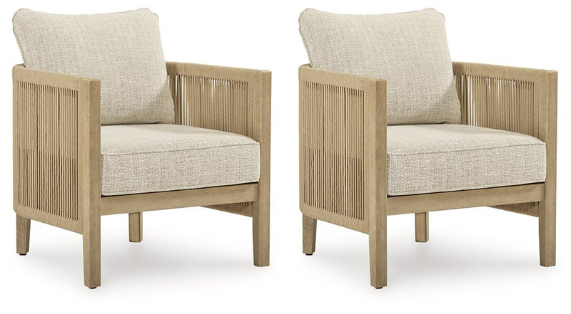 Two Ashley Furniture Spooners Cove outdoor lounge chairs with cushions, shown from an angled side view in a garden setting.