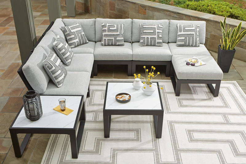 Ashley Furniture Beachloft outdoor seating set with cushioned chairs and a matching table on a patio.